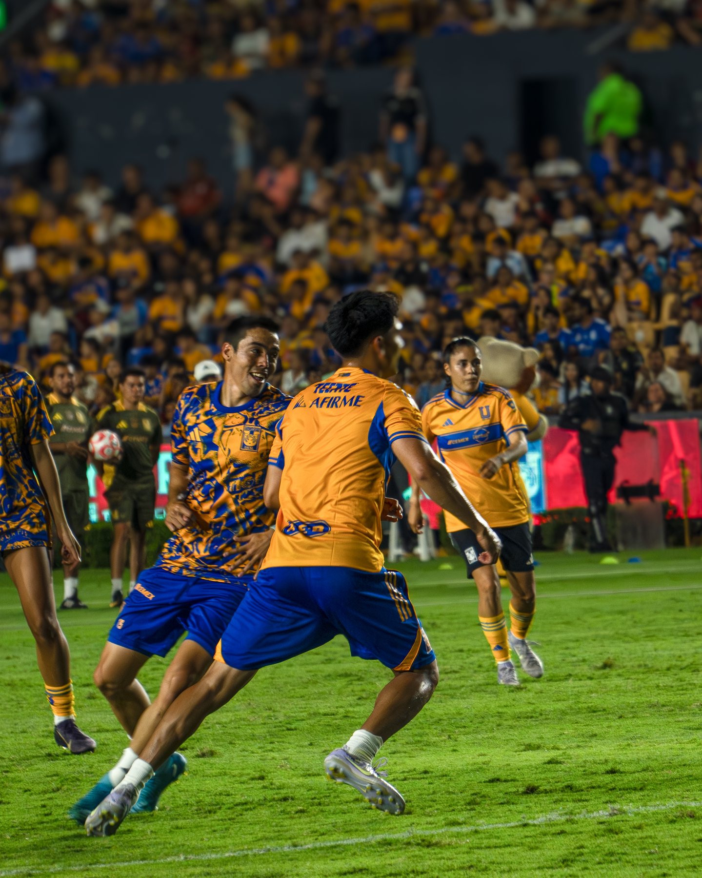 Jugadoras de Tigres disputando el balón en el césped