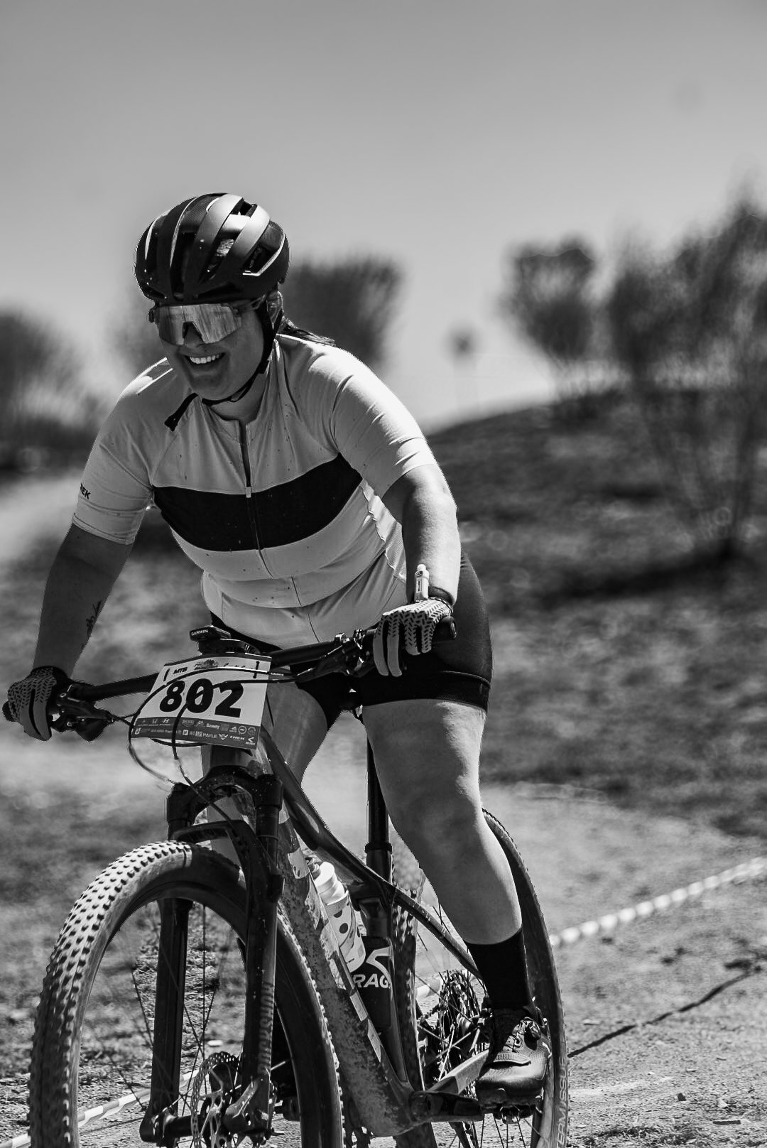 Retrato en blanco y negro de una ciclista en competencia